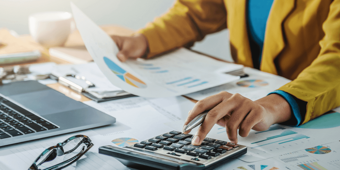 Woman reviewing her financial documents while using a calculator