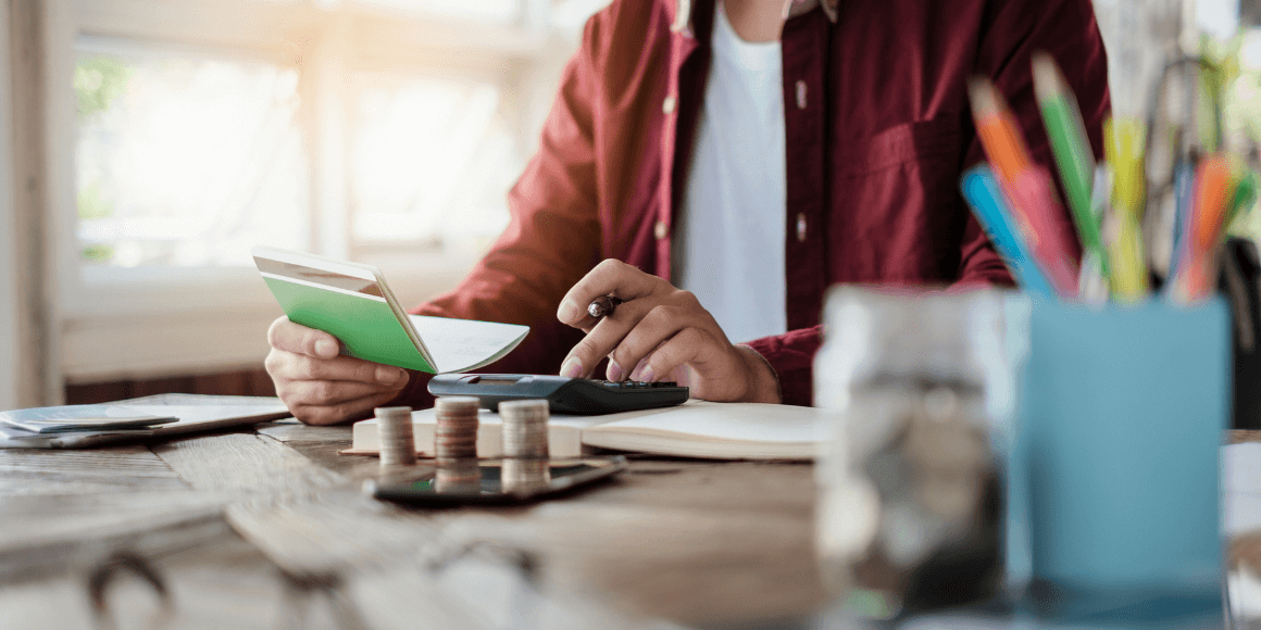 Man sitting at his desk and balancing his checkbook