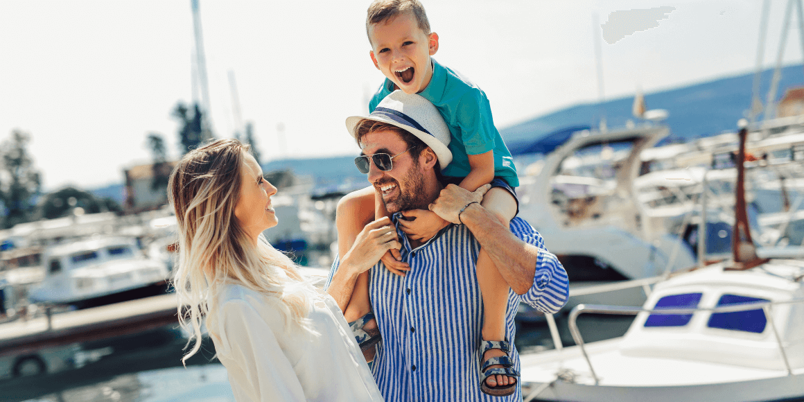 Family celebrating their new boat purchase at a marina, made possible through 7 17 Credit Union