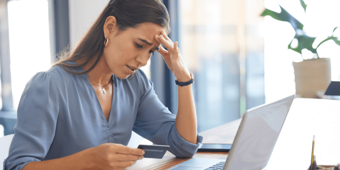 A concerned woman checking her credit card details on her laptop.