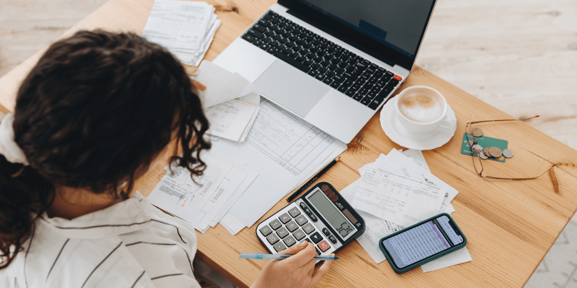 top view of a woman using a new budgeting strategy to plan for the month