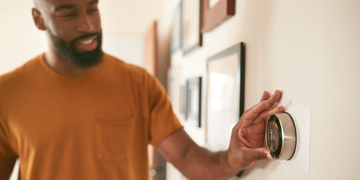 Homeowner adjusting the temperature on the thermostat