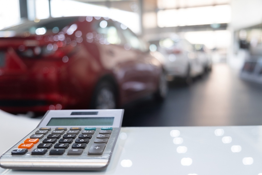First person view of a a car showroom with a calculator on the table