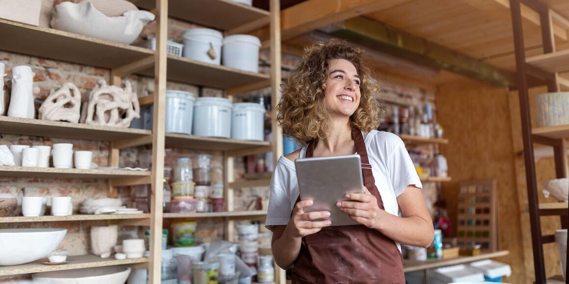 A female small business owner using a tablet in her shop