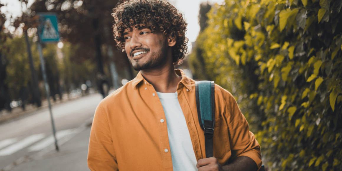 young college student happily walking around campus