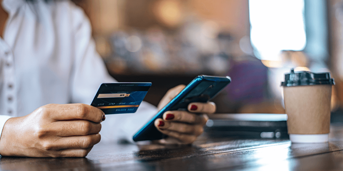 woman paying for her mobile order at a coffee shop with a credit card