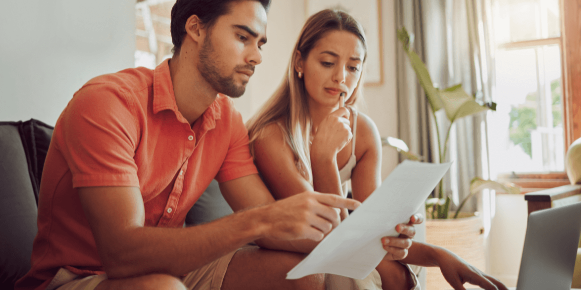Couple sitting on the couch reviewing statements and paying their bills