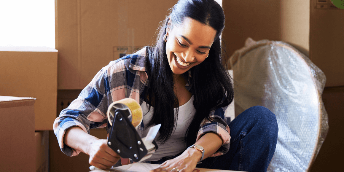 Woman taping a box and getting ready to move