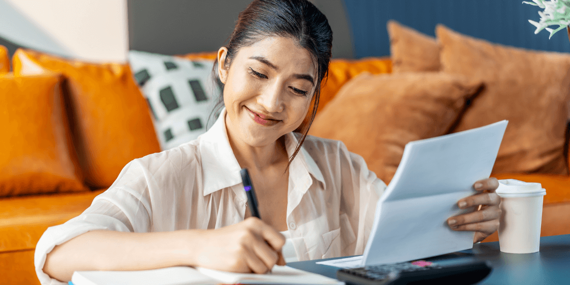 Woman sitting in her living room while reviewing her checking account statement