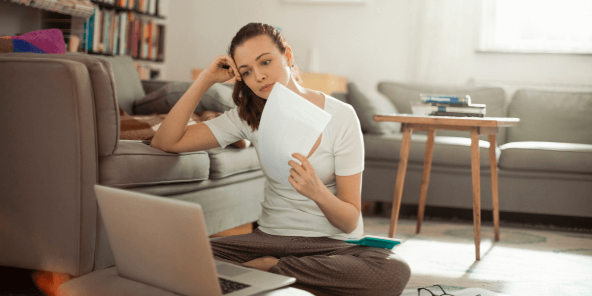 young woman sitting on the floor reviewing her financial statements