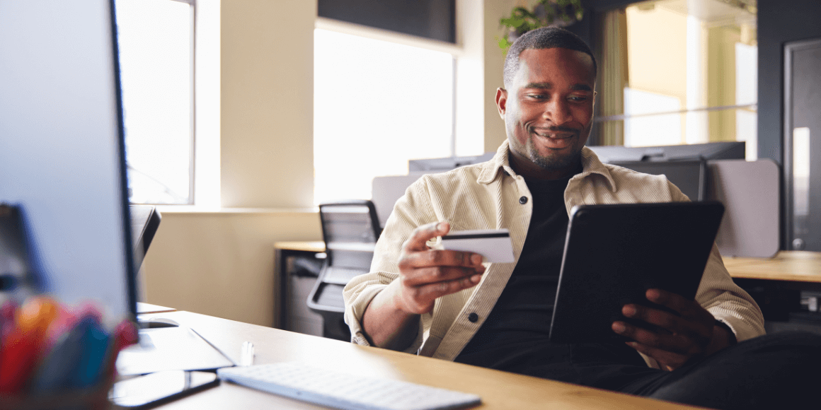 Happy man establishing good credit habits by paying his bills online 