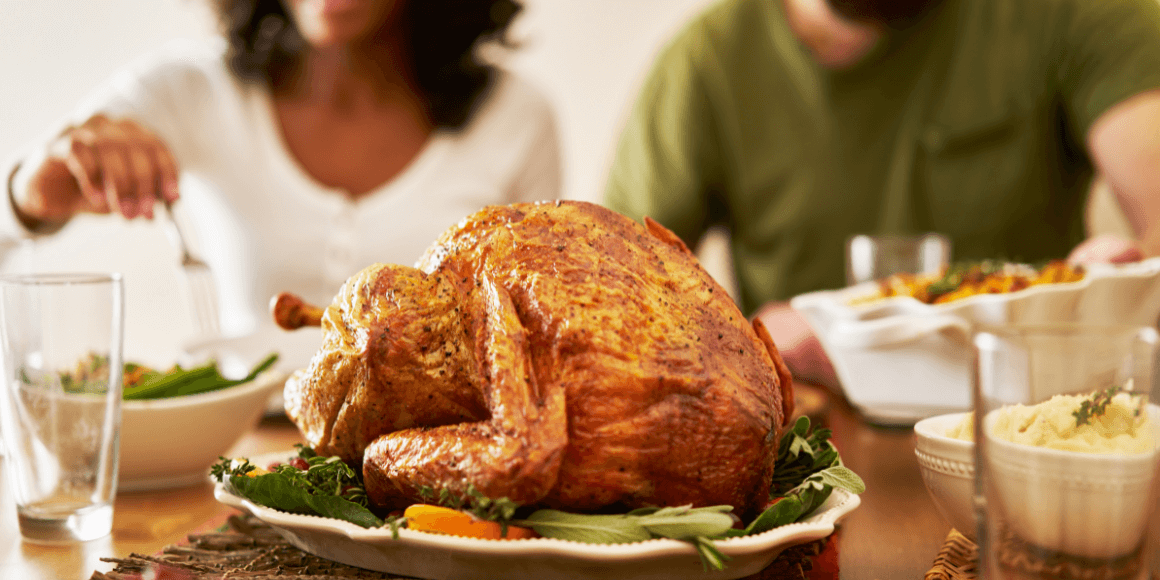 Thanksgiving turkey on a table with people eating in the background