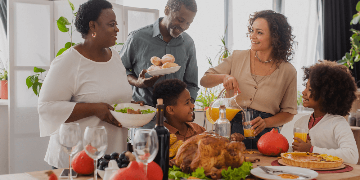 parents, grandparents and children setting the table for thanksgiving dinner