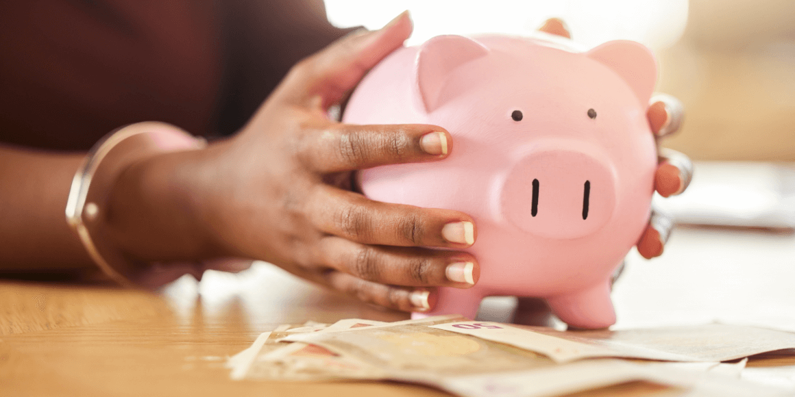 black woman holding a piggy bank containing their emergency savings