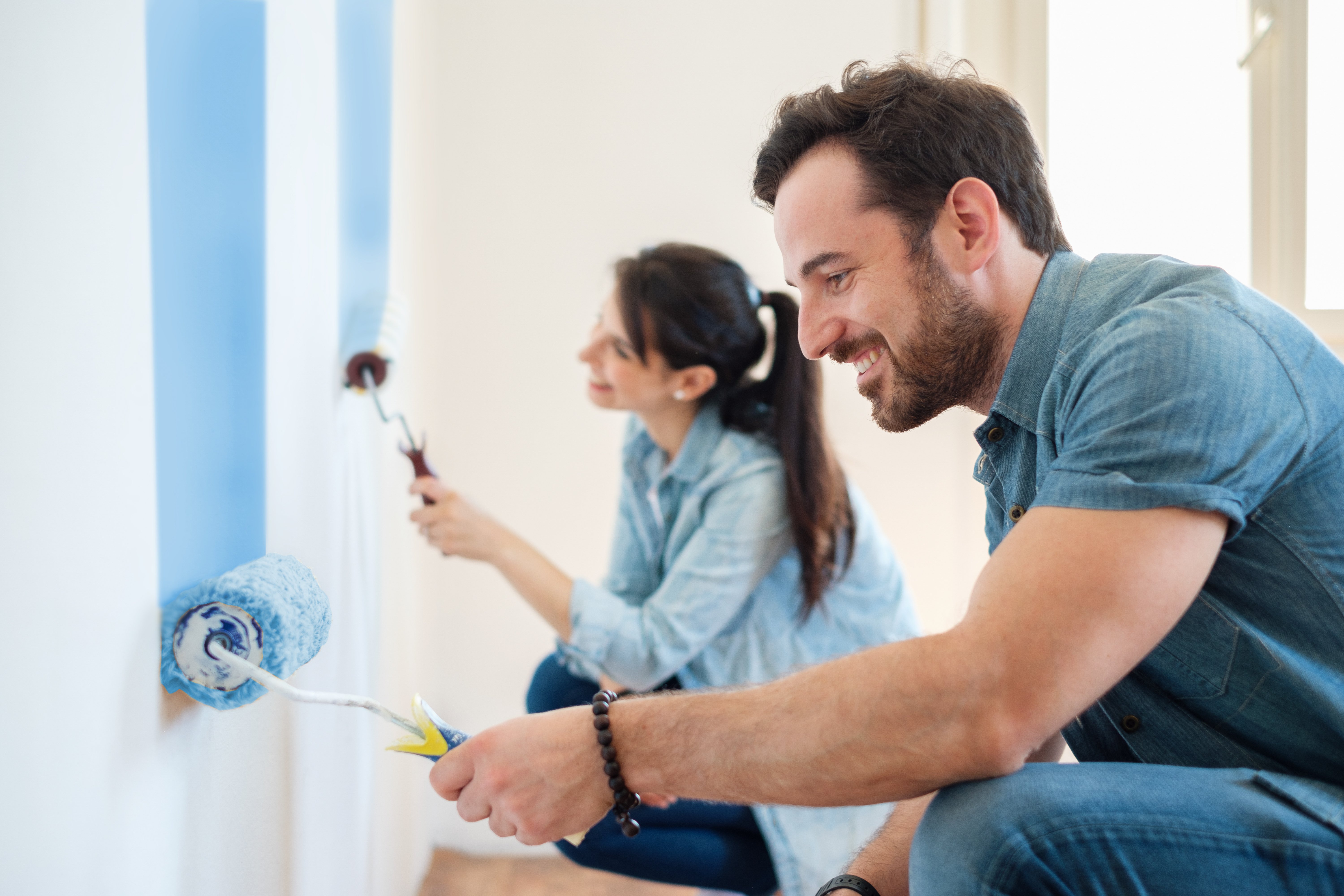 couple in new home painting wall together