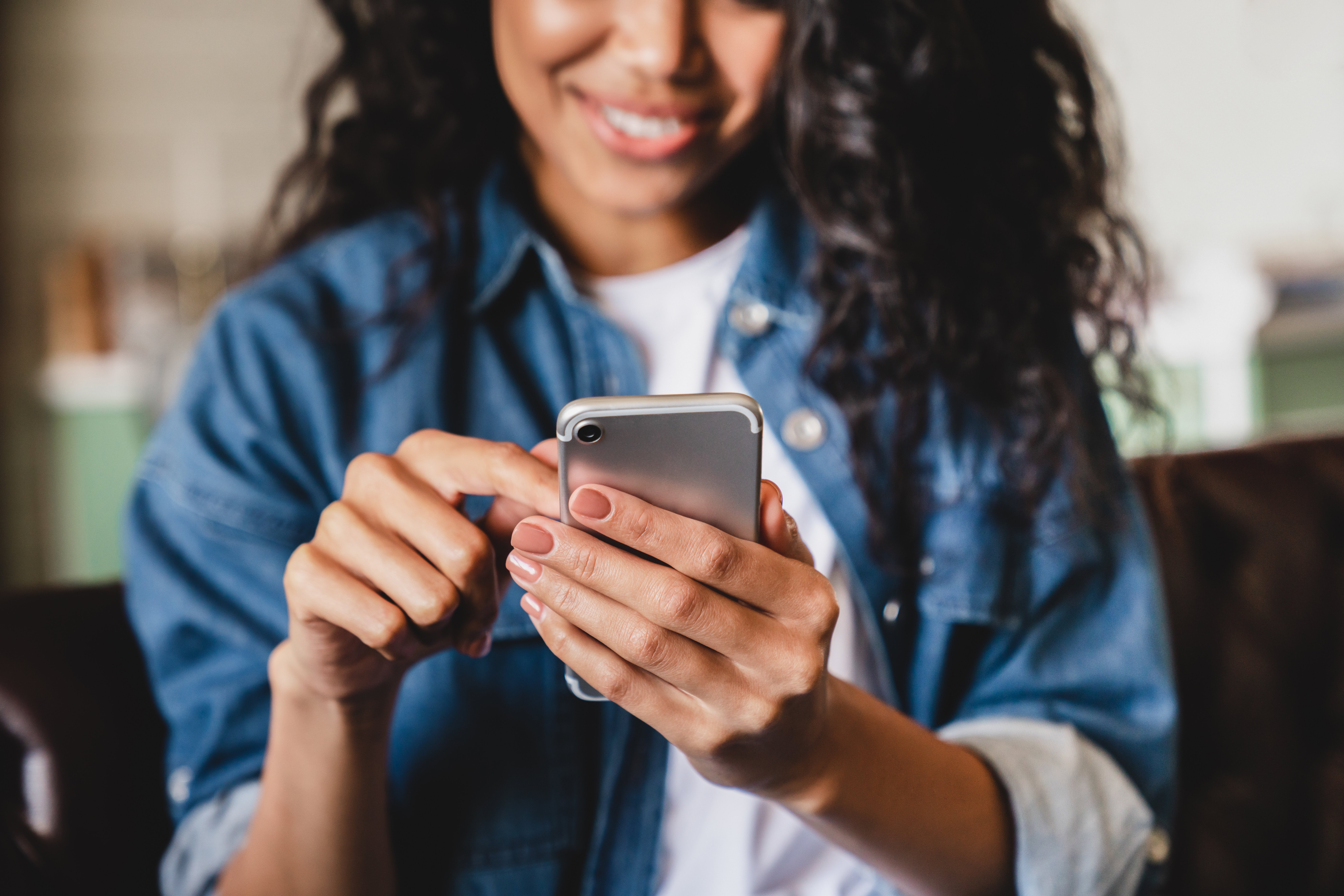 Young smiling woman using smartphone to check her credit score